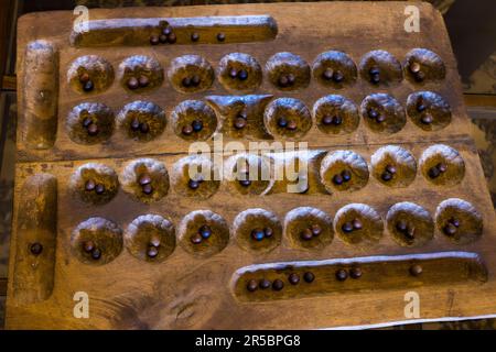Un antico gioco di Bao con semi di tè usati come pezzi si trova nella lobby di Huntingdon House nella tenuta di Satemwa vicino a Thyolo, Malawi. Bao è un gioco di mancala; il nome significa "tavola" in swahili, e si gioca con semi posti in buche scavate. In Malawi è anche conosciuto come Bawo. Foto Stock