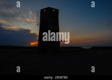 La silhouette di una torre sullo sfondo di un cielo al tramonto. Miramar, Argentina. Foto Stock