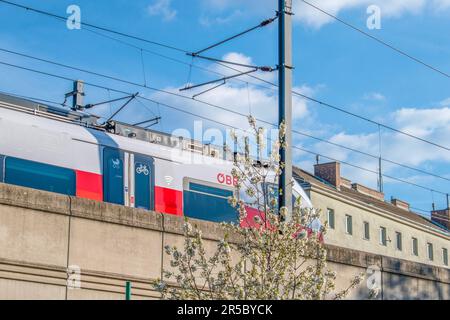 vienna, austria. 4 aprile 2023. i treni delle ferrovie austriache viaggiano sul ponte ferroviario della città. passeggero espresso Foto Stock