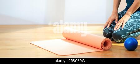 Interni in studio Pilates, concetto di allenamento e fitness. Istruttore seduto di fronte a un tappeto yoga closeup, spazio copia Foto Stock