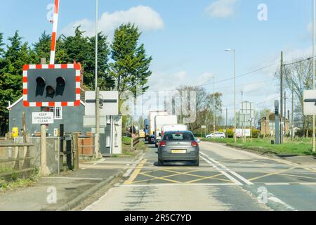 Attraversamento a livello ferroviario con luci e barriere al ponte Swineshead sulla A17. La vista è a nord. Foto Stock