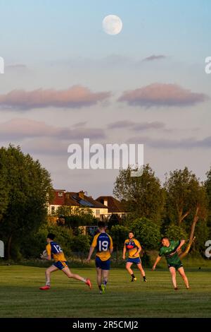 Londra, Regno Unito. 2 giugno 2023. Il tempo del Regno Unito – Una luna gibbosa in calo del 97,5 % si erge dietro una partita di calcio gaelico su un campo di gioco vicino al Wembley Stadium, nel nord-ovest di Londra, davanti allo Strawberry Moon di domani. La luna piena di giugno, secondo l'Almanacco dell'Old Farmer, è così chiamata come era il segnale per le tribù dei nativi americani Algonquin di raccogliere fragole selvatiche. Manchester City gioca il Manchester United nella finale della Coppa fa domani pomeriggio e quando vincono, di solito festeggiano suonando la canzone "Blue Moon". Credit: Stephen Chung / Alamy Live News Foto Stock