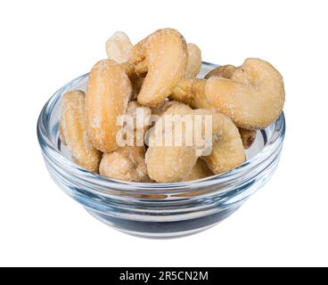 Closeup una ciotola di vetro con le noci di anacardi salate isolate su fondo bianco. Gustose anacardi arrostiti con cristalli di sale in un piccolo piatto rotondo pieno di vitamina. Foto Stock