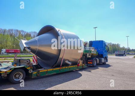 AQUISGRANA, NRW, GERMANIA - 18 aprile 2019: Trasporto pesante di un grande container in acciaio inossidabile su un autocarro con caricatore basso, parcheggio a un'fermata Foto Stock