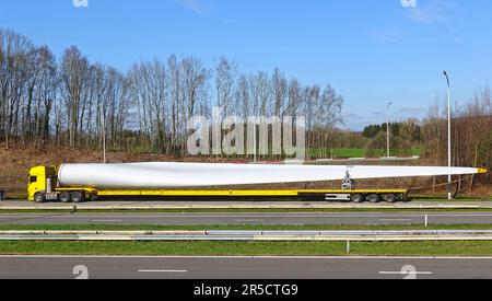 Parcheggio a bordo strada camion speciale con carico di grandi dimensioni che trasporta una pala del rotore per turbine di centrali eoliche Foto Stock