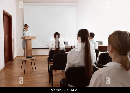 Dottore in conferenza in sala conferenze con schermo di proiezione Foto Stock