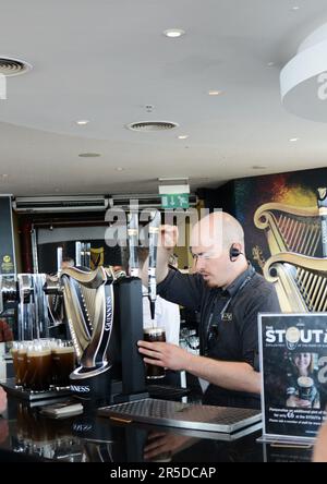 Gusterete una pinta di Guinness Stout al bar sul tetto della Guinness Storehouse di St James's Gate a Dublino, Irlanda. Foto Stock