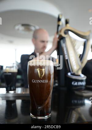 Gusterete una pinta di Guinness Stout al bar sul tetto della Guinness Storehouse di St James's Gate a Dublino, Irlanda. Foto Stock