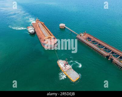 Veduta aerea dei rimorchiatori che spostano una grande barca verso un pontile a Whyalla, nell'Australia Meridionale Foto Stock