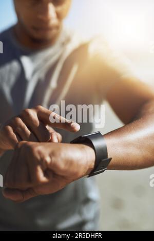 Pronti, pronti, via. Primo piano di un uomo irriconoscibile che controlla il suo smartwatch mentre si esercita all'aperto. Foto Stock