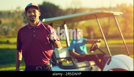 Il golf è un gioco per Signore. Ritratto di un golfista che tiene il suo club con un buggy sfocato sullo sfondo. Foto Stock
