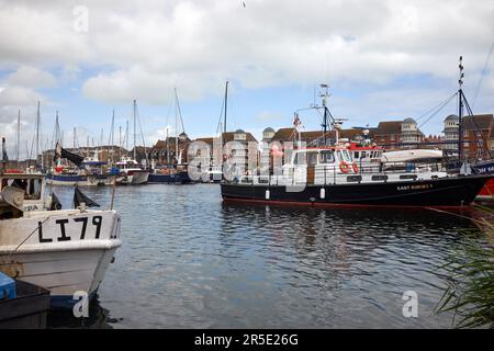 Eastbourne, East Sussex, Regno Unito - Agosto 7 2021: Yacht a Sovereign Harbour con edifici di appartamenti sullo sfondo. Foto Stock