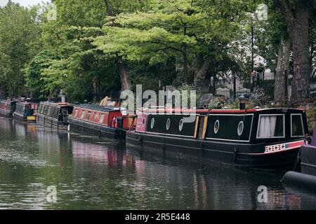 File di case galleggianti e barche strette sul canale del Regent su Maida Avenue, Little Venice, West London, in un luminoso giorno autunnale. Foto Stock
