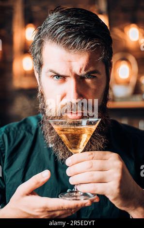 Barman con martini o liquore. Uomo porticato vestito e bere alcol. Concetto di drink e festa di festa. Degustazione e degustazione. Foto Stock