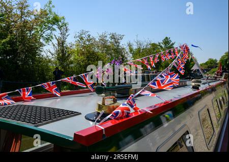 Union Jack si accatastava sul tetto di una nave da crociera sotto il sole estivo con alberi sullo sfondo. Foto Stock