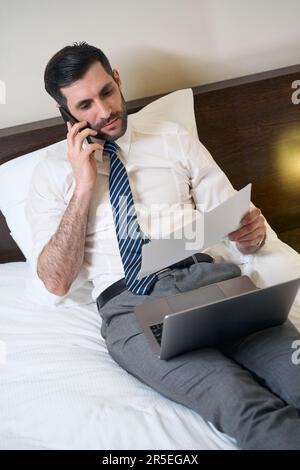 Maschile in ufficio vestiti si trova su un grande letto Foto Stock