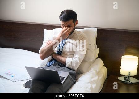 Uomini stanchi lottano con il sonno mentre lavorano su documenti Foto Stock