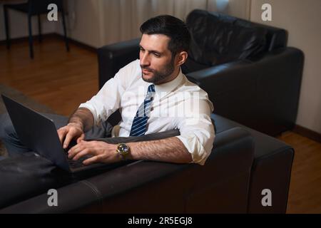 Un uomo d'affari di media età in viaggio d'affari lavora dalla camera dell'hotel Foto Stock