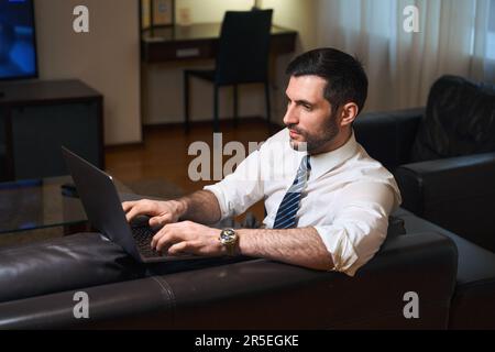 Un uomo d'affari in viaggio d'affari lavora da una camera d'albergo Foto Stock