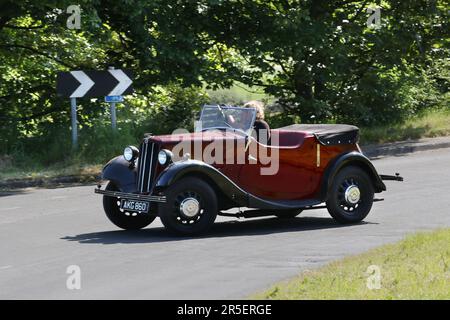 Anni '1937 30 Red Black MORRIS berlina da 885 cc con tetto aperto che viaggia a Chorley, Regno Unito Foto Stock