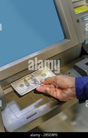 Dettaglio di una mano dell'uomo che prende le fatture del dollaro da un ATM. Foto Stock