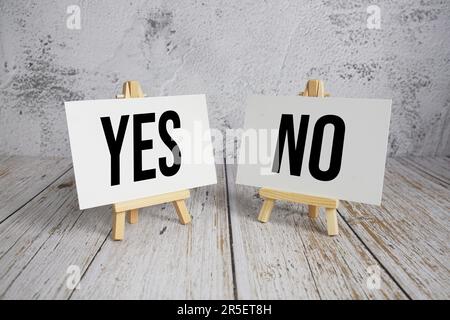Sì o No messaggio di testo e sveglia su sfondo di legno Foto Stock