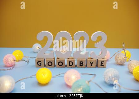 Addio 2023 lettere con decorazione a sfere di cotone a LED su sfondo blu Foto Stock