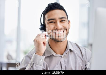 Uomo indiano, call center e ritratto del lavoro alla scrivania dell'ufficio, al computer o al lavoro di telemarketing, comunicazione o vendita. Agente, dipendente felice o. Foto Stock