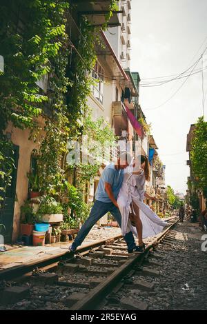 La vita è stata fatta per ballare e romancing. Una coppia felice che condivide un momento romantico sulle piste dei treni per le strade del Vietnam. Foto Stock