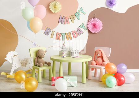 Interno per la festa di compleanno dei bambini con palloncini, giocattoli e mobili Foto Stock