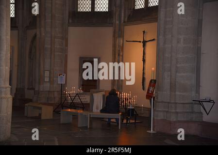 Utrecht, Paesi Bassi. Maggio 2023. Donna che prega nella chiesa del Duomo di Utrecht. Foto di alta qualità Foto Stock