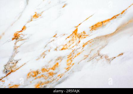 Texture marmo bianco latteo con venature e spruzzi d'arancio brillante Foto Stock