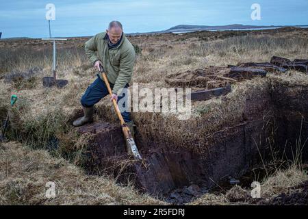 Cesoia per torba al lavoro sulle rive del Loch Gorm a Islay, Scozia Foto Stock