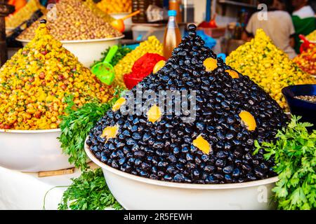 Vari tipi di olive sul banco. Mercato marocchino. Essaouira, Marocco - 20 settembre 2019. Foto Stock