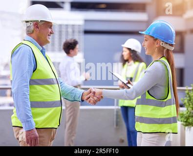 Personale di costruzione, stretta di mano e affari di gestione di architetto in un cantiere. Team di progettazione, agitando le mani e il personale con il consenso Foto Stock