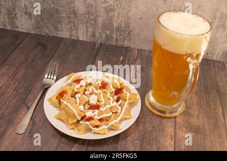 Deliziosa casa calda ceco tradizionale gulasch di manzo servita con cotti al vapore Gnocchi cechi o knedliky sulla piastra nera sul tavolo in legno con vetro di bee Foto Stock