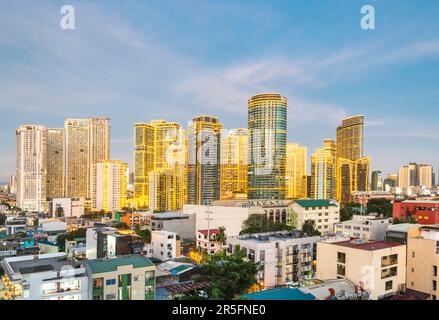 Dopo il tramonto, i moderni e alti edifici di appartamenti e uffici di Makaiti prendono vita, quando le splendide luci a striscia dorate e lucenti coprono Foto Stock