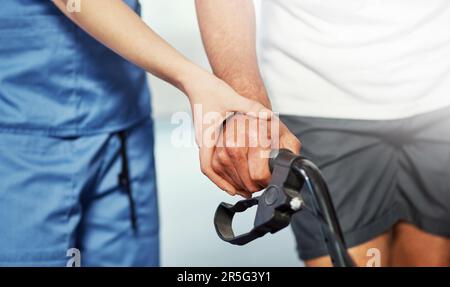 Dargli una mano guida. un'infermiera irriconoscibile e il suo paziente di sesso maschile senior che lavora al suo recupero. Foto Stock