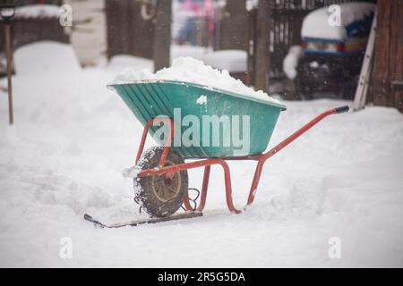 carriola con neve in inverno Foto Stock