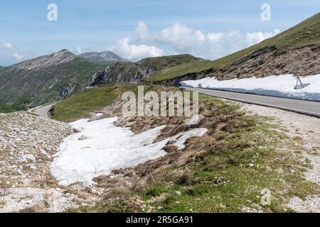 Paesaggio montano nella catena appenninica vicino al Monte Terminillo nel mese di maggio, Italia centrale, Europa, con neve sul lato della strada Foto Stock