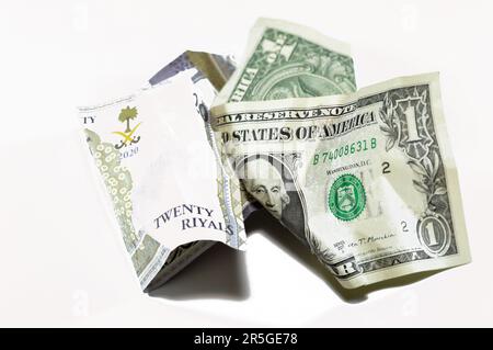 Corrugato e sbriciolato Arabia Saudita denaro di 20 SAR venti riyals e 1 un dollaro americano denaro contante, inflazione di denaro e perdita di valore, concetto di caduta, Foto Stock
