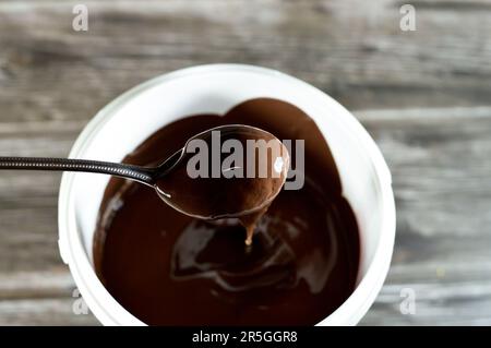 crema di cacao zuccherato alle nocciole, crema di torrone al cioccolato, consistenza di pasta di cioccolato fusa utilizzata nel panificio di caramelle, waffle e molti altri dessert Foto Stock