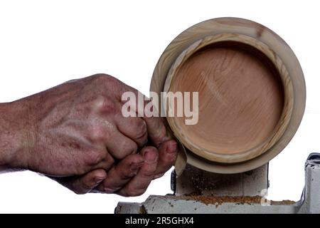 Artigiano che crea una ciotola di legno sul tornio. Immagine in officina. Sfondo bianco. Foto Stock