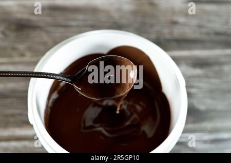 crema di cacao zuccherato alle nocciole, crema di torrone al cioccolato, consistenza di pasta di cioccolato fusa utilizzata nel panificio di caramelle, waffle e molti altri dessert Foto Stock