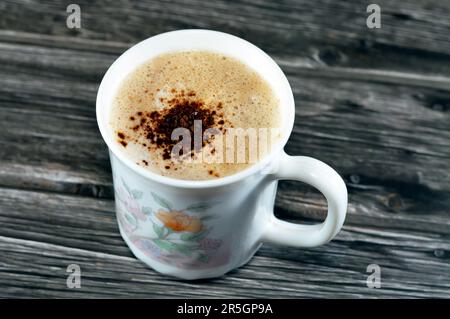 Una tazza di cappuccino con schiuma cremosa e caffè, una bevanda a base di caffè espresso preparata tradizionalmente con schiuma di latte al vapore micro fo Foto Stock