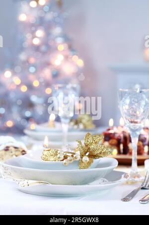 Place setting with Christmas tree in background Foto Stock