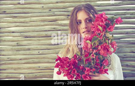 Niente dice la femminilità come i fiori. una giovane donna attraente che tiene un mazzo di fiori freschi. Foto Stock