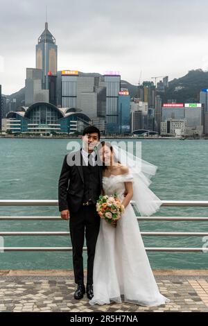 Una coppia appena sposata posa per Una fotografia sullo sfondo dell'Isola di Hong Kong, Hong Kong, Cina. Foto Stock