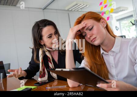 Una donna d'affari cerca di confortare la sua collega, triste e stressata Foto Stock