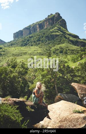 È il giorno perfetto per essere all'aperto. Ripresa a tutta lunghezza di una giovane donna attraente seduta da sola sul bordo di una roccia durante una giornata all'aperto. Foto Stock